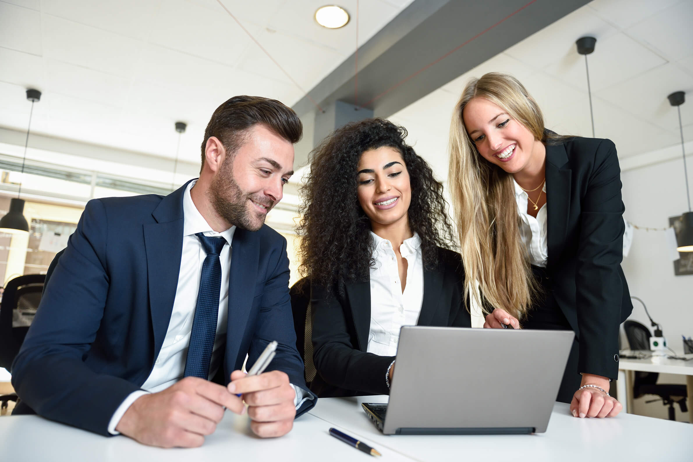 Colleagues smiling as they look at laptop