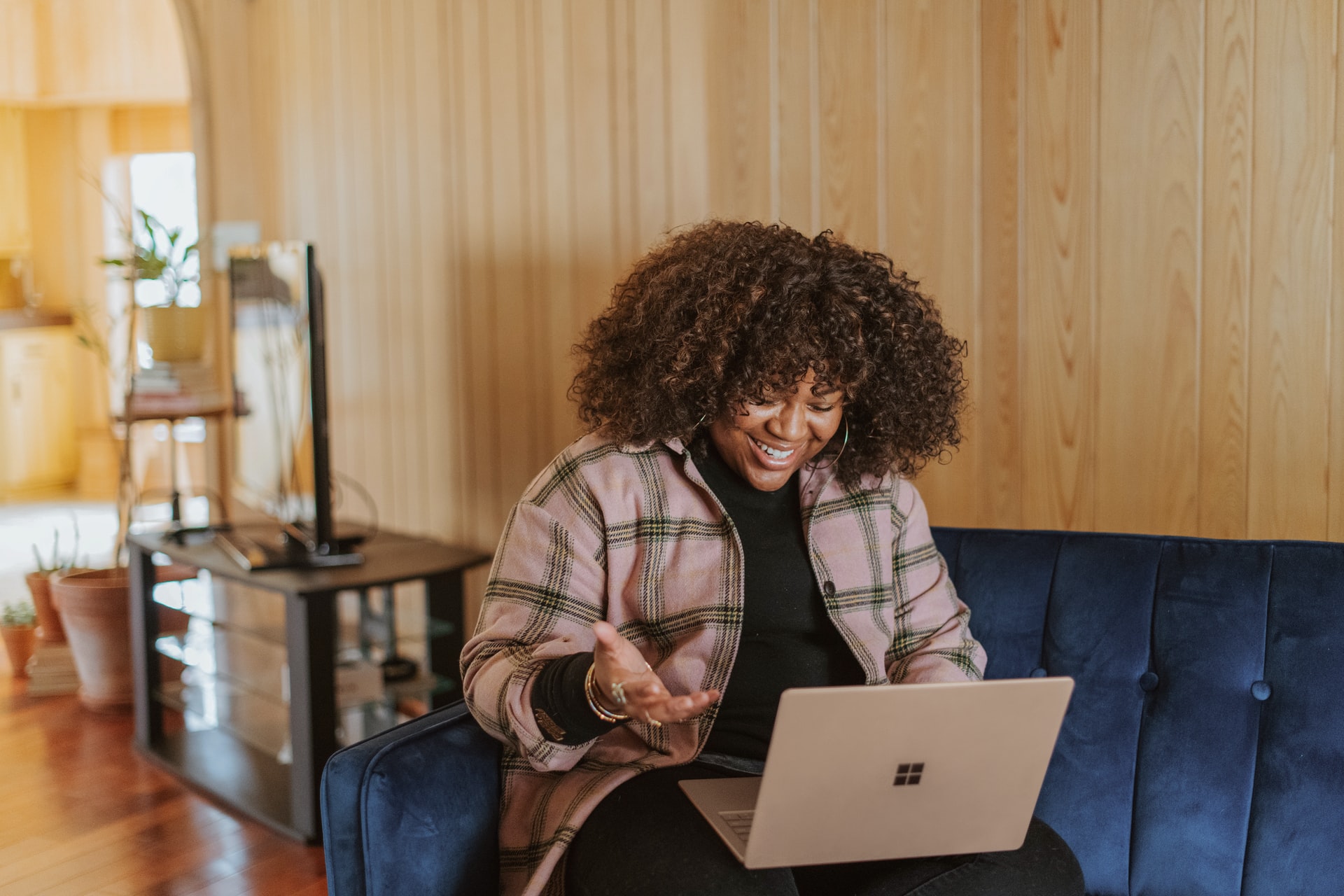 Azure and WVD: the ideal hosted virtual desktop solution in the cloud - woman smiles while looking at a Microsoft Teams meeting. There is some furniture in the background.